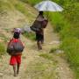 Indonésie - Villageois qui reviennent de Wamena a pied avec leurs courses, ils ont parfois jusqu a 7 jours de marche pour rentrer! toute la famille est du voyage et meme les plus jeunes portent les courses avec leurs sacs sur la tete!
